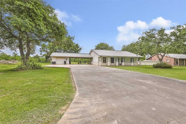 881 County Road 2276, Cleveland, TX 77327 - ranch-style house with concrete driveway, a carport, a front yard, metal roof, and a porch
