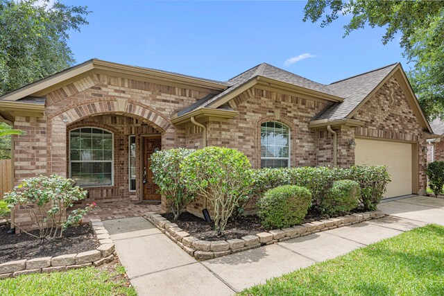 26019 Pagemill Ln, Richmond, TX 77406 - view of front of property with brick siding, an attached garage, concrete driveway, and roof with shingles