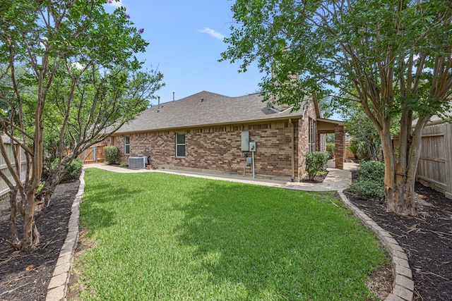 26019 Pagemill Ln, Richmond, TX 77406 - rear view of property with central AC, a shingled roof, brick siding, and a patio
