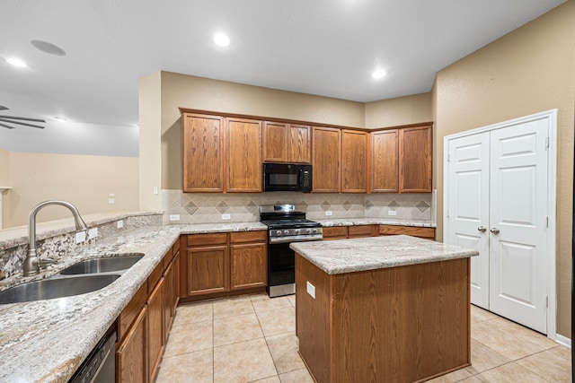 26019 Pagemill Ln, Richmond, TX 77406 - kitchen featuring stainless steel gas range oven, black microwave, a sink, tasteful backsplash, and light stone counters