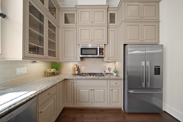 1317 Roy St, Houston, TX 77007 - kitchen with appliances with stainless steel finishes, decorative backsplash, light stone counters, dark wood-type flooring, and cream cabinetry