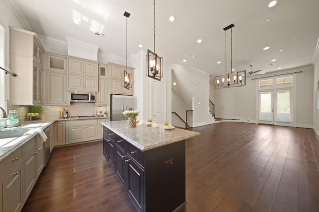 1317 Roy St, Houston, TX 77007 - kitchen featuring appliances with stainless steel finishes, ornamental molding, a kitchen island, recessed lighting, and glass insert cabinets