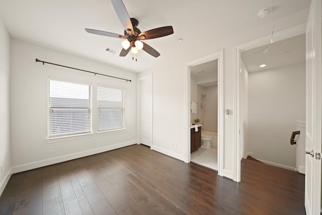 1317 Roy St, Houston, TX 77007 - unfurnished bedroom featuring dark wood-type flooring, baseboards, connected bathroom, and a ceiling fan