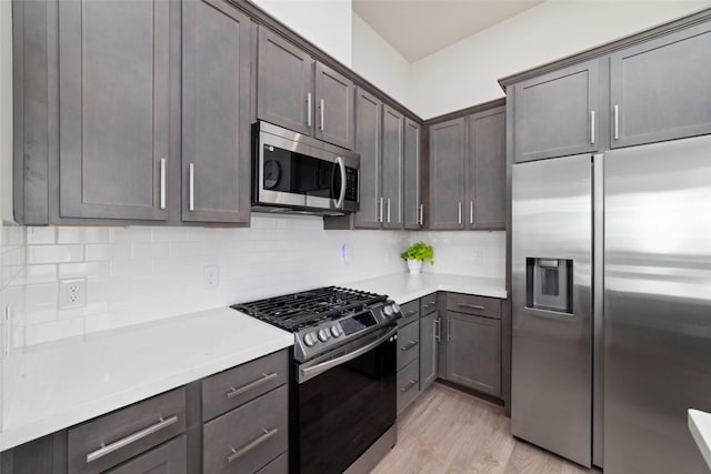 6307 Chelsea Falls Ln, Houston, TX 77008 - kitchen with stainless steel appliances, light wood-style flooring, light countertops, tasteful backsplash, and dark brown cabinetry