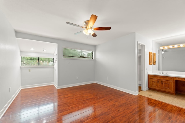 12203 Ashley Circle Dr E, Houston, TX 77071 - unfurnished bedroom with a sink, light wood-style flooring, baseboards, a ceiling fan, and ensuite bathroom