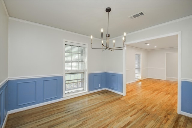 5007 Redstart St, Houston, TX 77035 - spare room featuring a chandelier, light wood-style floors, a wainscoted wall, ornamental molding, and a decorative wall