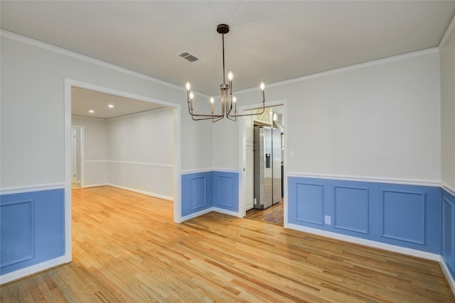 5007 Redstart St, Houston, TX 77035 - unfurnished room with crown molding, light wood-style floors, a chandelier, and a wainscoted wall