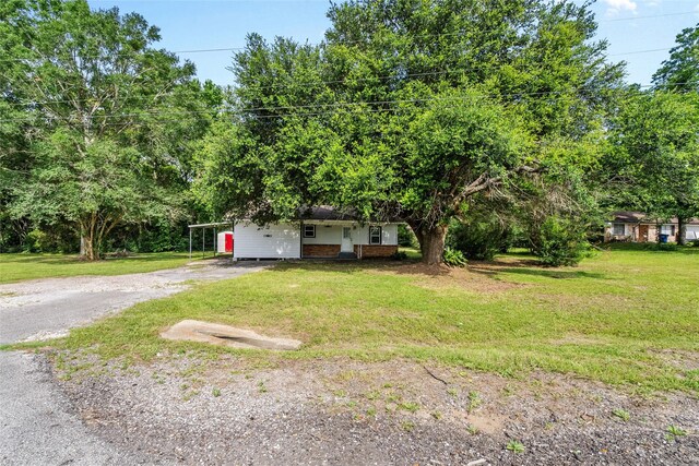 7650 US Highway 69 S, Woodville, TX 75979 - view of front of home featuring dirt driveway, a front yard, and brick siding