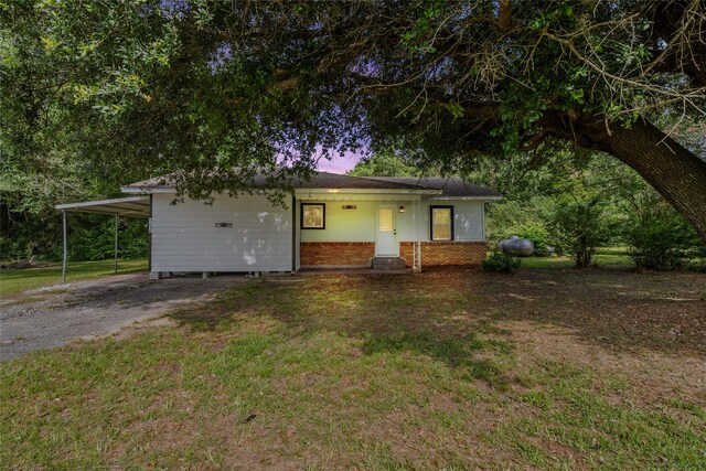 7650 US Highway 69 S, Woodville, TX 75979 - view of front of home featuring a yard, a carport, brick siding, and driveway