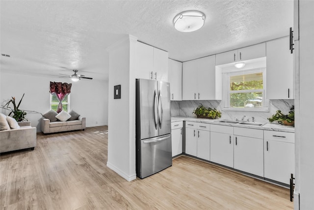 7650 US Highway 69 S, Woodville, TX 75979 - kitchen featuring freestanding refrigerator, light countertops, light wood-type flooring, a ceiling fan, and a textured ceiling