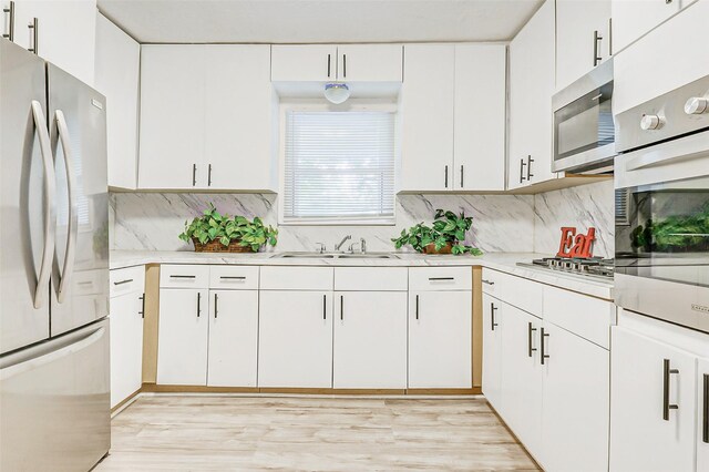 7650 US Highway 69 S, Woodville, TX 75979 - kitchen featuring appliances with stainless steel finishes, light countertops, decorative backsplash, and white cabinets