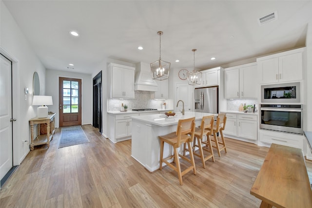 2331 Hagerman Rd, Conroe, TX 77384 - kitchen with stainless steel appliances, light countertops, custom range hood, tasteful backsplash, and a breakfast bar