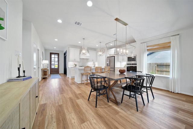 2331 Hagerman Rd, Conroe, TX 77384 - dining area with light wood-style flooring, a chandelier, recessed lighting, and baseboards