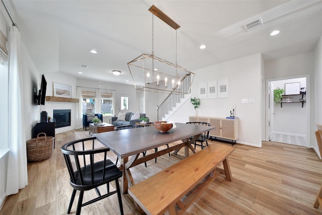 2331 Hagerman Rd, Conroe, TX 77384 - dining area featuring stairs, a glass covered fireplace, recessed lighting, light wood finished floors, and a chandelier