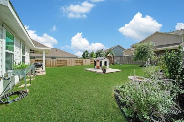 2331 Hagerman Rd, Conroe, TX 77384 - view of yard featuring a playground, ceiling fan, and a storage shed