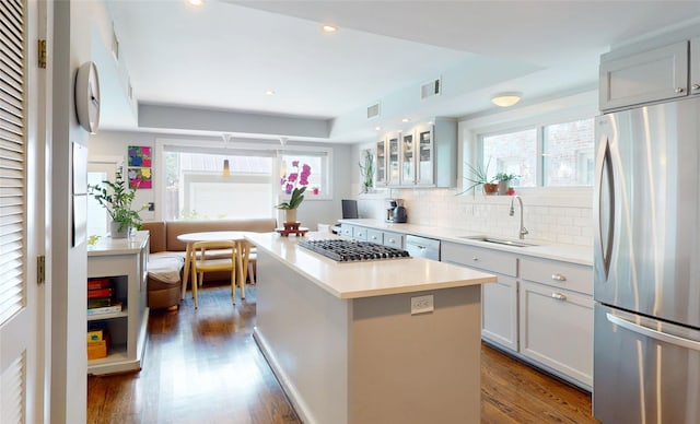 2737 Werlein Ave, Houston, TX 77005 - kitchen featuring stainless steel appliances, a sink, wood finished floors, backsplash, and a kitchen island