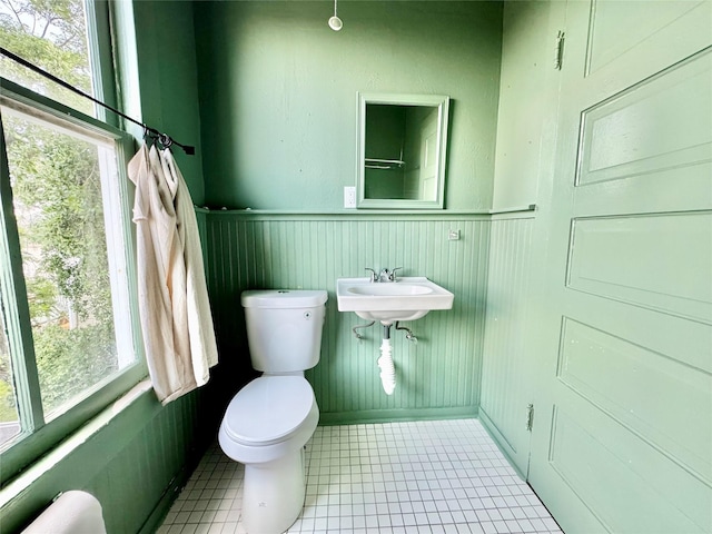 1317 Church St, Galveston, TX 77550 - bathroom with toilet, a wainscoted wall, tile patterned flooring, and a sink