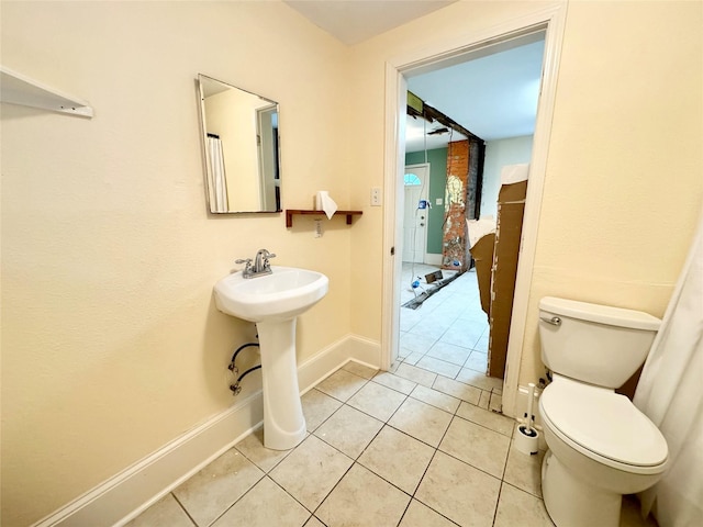 1317 Church St, Galveston, TX 77550 - bathroom featuring toilet, baseboards, tile patterned floors, and a sink