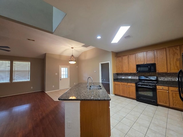 19518 Grand Colony Ct, Katy, TX 77449 - kitchen with black appliances, a sink, tasteful backsplash, light tile patterned floors, and lofted ceiling