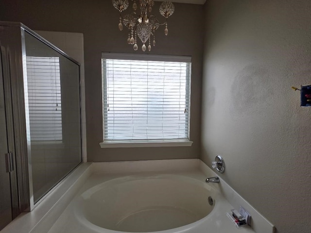 19518 Grand Colony Ct, Katy, TX 77449 - full bathroom with healthy amount of natural light, a garden tub, and a chandelier
