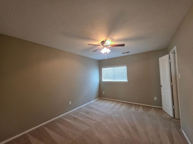 19518 Grand Colony Ct, Katy, TX 77449 - empty room with baseboards, a ceiling fan, light carpet, and a textured ceiling