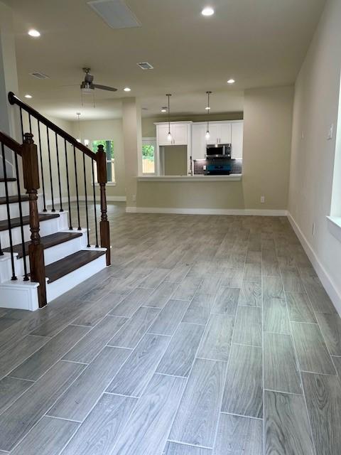 10516 Exeter St, Houston, TX 77093 - stairway with wood tiled floors, a ceiling fan, and recessed lighting