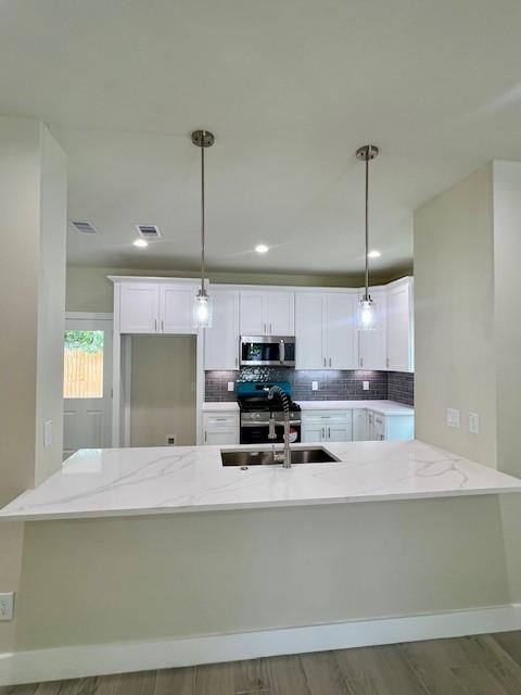 10516 Exeter St, Houston, TX 77093 - kitchen with stainless steel appliances, light stone countertops, white cabinets, and backsplash