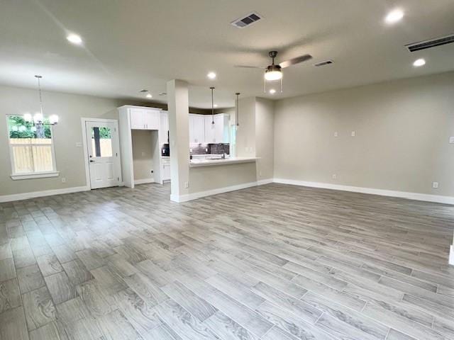 10516 Exeter St, Houston, TX 77093 - unfurnished living room with light wood-style floors, a ceiling fan, recessed lighting, and a chandelier