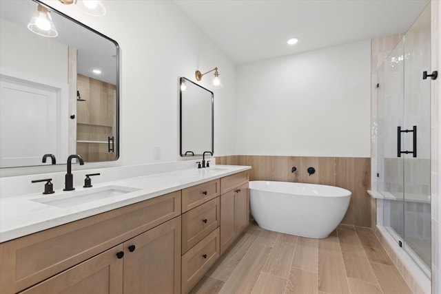 5306 San Juan St, Houston, TX 77020 - bathroom featuring a stall shower, double vanity, a freestanding tub, wainscoting, and recessed lighting
