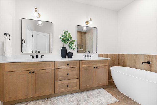 5306 San Juan St, Houston, TX 77020 - full bath with double vanity, a freestanding tub, and wood finished floors