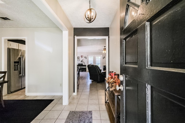 1510 Elmscott Dr, Sugar Land, TX 77498 - foyer entrance with light tile patterned floors, a textured ceiling, a chandelier, ceiling fan, and baseboards