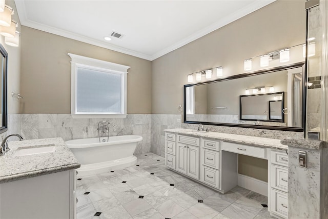 428 W 26th St, Houston, TX 77008 - bathroom with two vanities, a freestanding tub, crown molding, tile walls, and a wainscoted wall