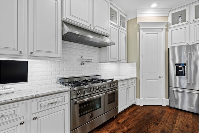 428 W 26th St, Houston, TX 77008 - kitchen featuring premium appliances, under cabinet range hood, white cabinetry, backsplash, and ornamental molding