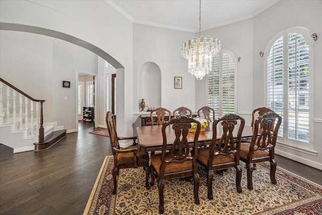 13627 Ashley Run, Houston, TX 77077 - dining room with healthy amount of natural light, arched walkways, dark wood finished floors, crown molding, and baseboards