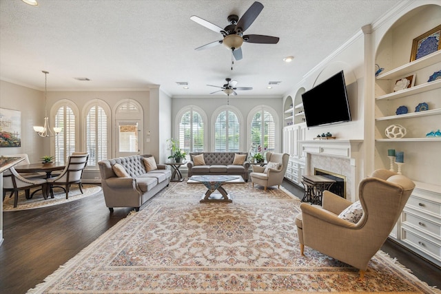 13627 Ashley Run, Houston, TX 77077 - living room featuring a textured ceiling, wood finished floors, a fireplace, ceiling fan, and ornamental molding