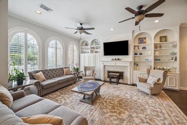 13627 Ashley Run, Houston, TX 77077 - living area featuring a ceiling fan, crown molding, a fireplace with flush hearth, built in features, and recessed lighting