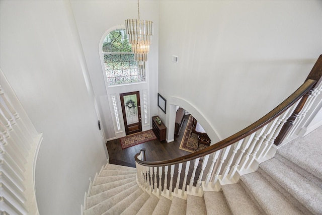 13627 Ashley Run, Houston, TX 77077 - entrance foyer with a high ceiling, a chandelier, stairway, wood finished floors, and arched walkways