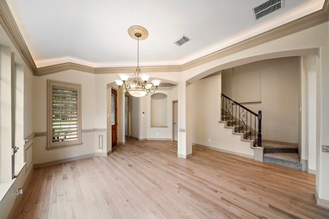 6823 Rosemont Park Ln, Katy, TX 77494 - unfurnished room featuring arched walkways, a chandelier, light wood finished floors, stairs, and crown molding