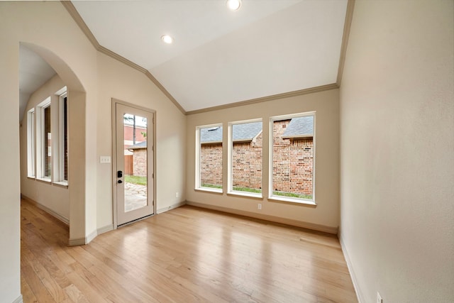 6823 Rosemont Park Ln, Katy, TX 77494 - spare room with ornamental molding, baseboards, light wood-type flooring, arched walkways, and vaulted ceiling