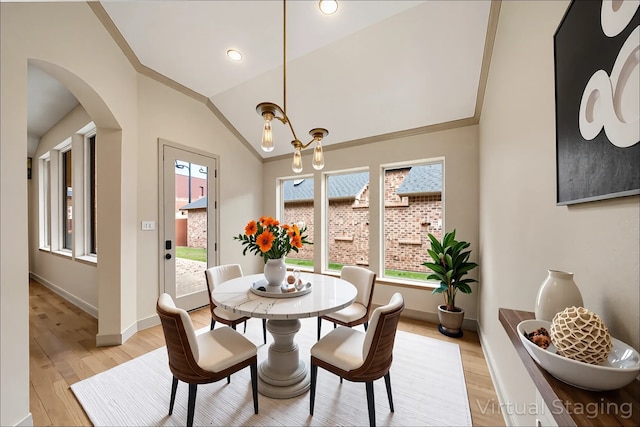 6823 Rosemont Park Ln, Katy, TX 77494 - dining area featuring light wood-style floors, arched walkways, lofted ceiling, and baseboards
