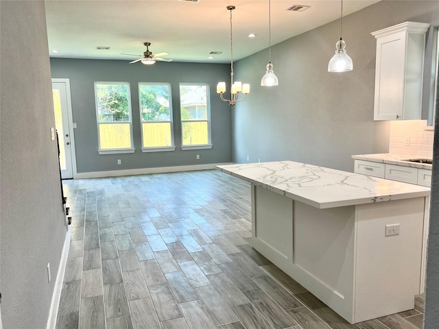 6804 Foster St, Houston, TX 77021 - kitchen with ceiling fan, wood finished floors, white cabinetry, baseboards, and a kitchen island