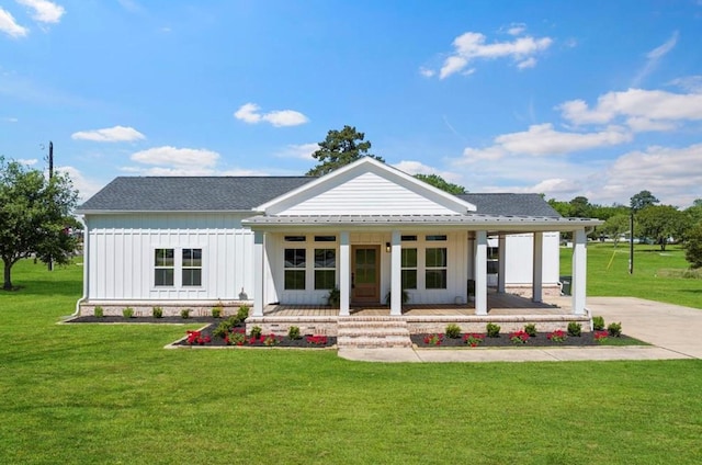 539 Elm St, New Ulm, TX 78950 - view of front of property featuring a porch, board and batten siding, concrete driveway, and a front lawn