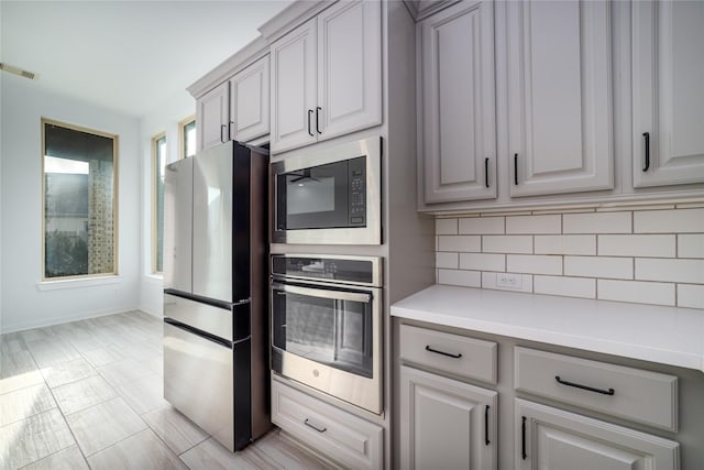 7822 Taronga Ln, Richmond, TX 77407 - kitchen with stainless steel appliances, tasteful backsplash, light countertops, and baseboards