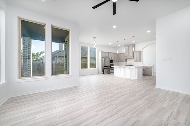 7822 Taronga Ln, Richmond, TX 77407 - unfurnished living room with ceiling fan, a sink, recessed lighting, arched walkways, and light wood-style flooring