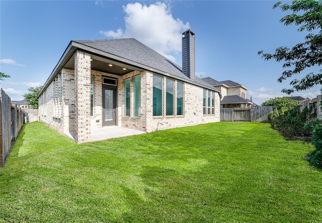 7822 Taronga Ln, Richmond, TX 77407 - back of property featuring brick siding, a chimney, a patio area, and roof with shingles