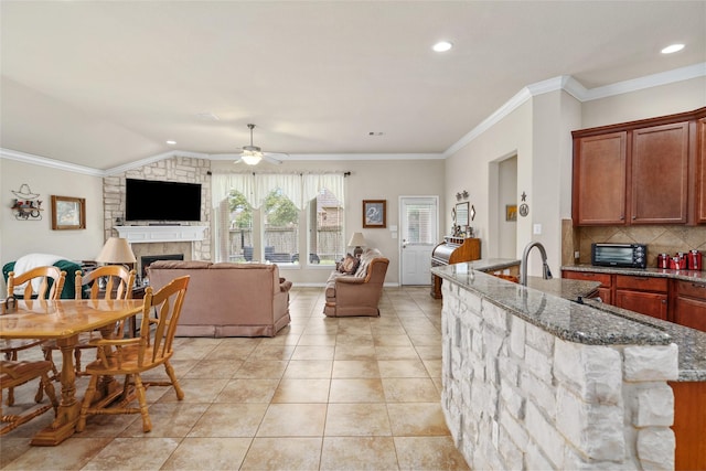 207 Lockridge Hill Ln, Richmond, TX 77469 - kitchen with open floor plan, a ceiling fan, stone counters, decorative backsplash, and a fireplace