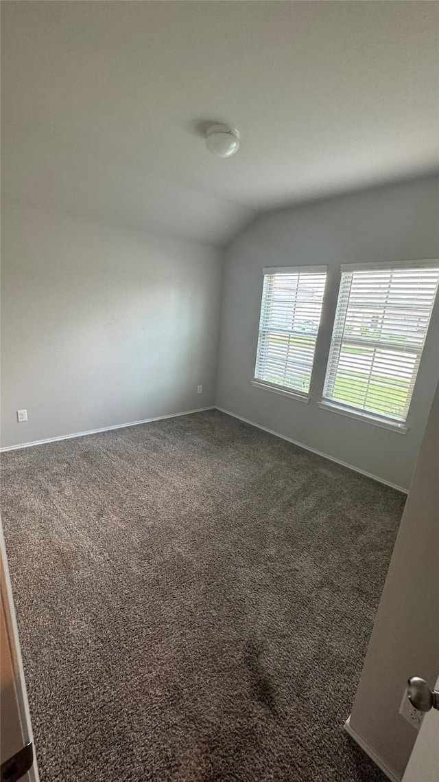 13909 Payette Arbor Ct, Conroe, TX 77384 - empty room featuring lofted ceiling, dark carpet, and baseboards
