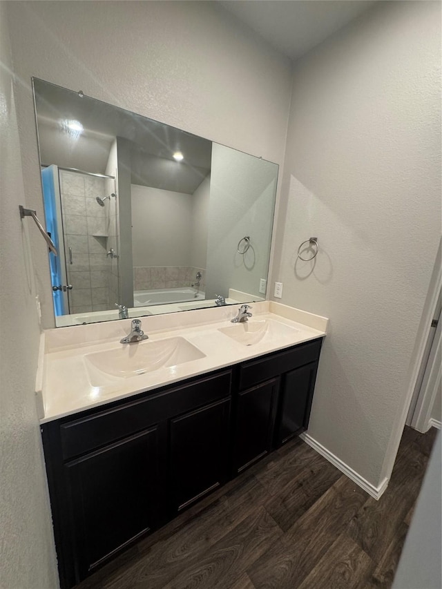 13909 Payette Arbor Ct, Conroe, TX 77384 - full bath featuring wood finished floors, a stall shower, a bath, double vanity, and baseboards