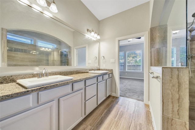 117 Saddle Dr, Houston, TX 77065 - bathroom featuring tiled shower, double vanity, wood finished floors, and baseboards