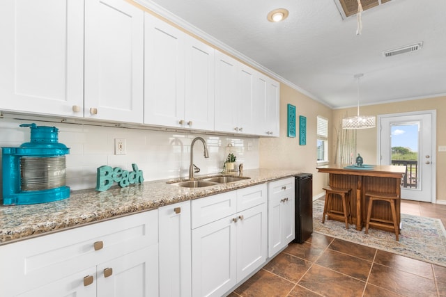 621 County Road 202, Sargent, TX 77414 - kitchen featuring a sink, tasteful backsplash, ornamental molding, white cabinetry, and baseboards